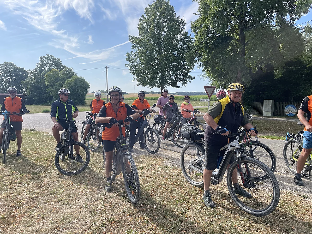Gruppe von Radfahrern mit Helmen steht mit Fahrrädern auf einem Feldweg bei sonnigem Wetter. Gemeinsame Radltour nach Harburg zum Abschluss der Stadtradel-Aktion 2026