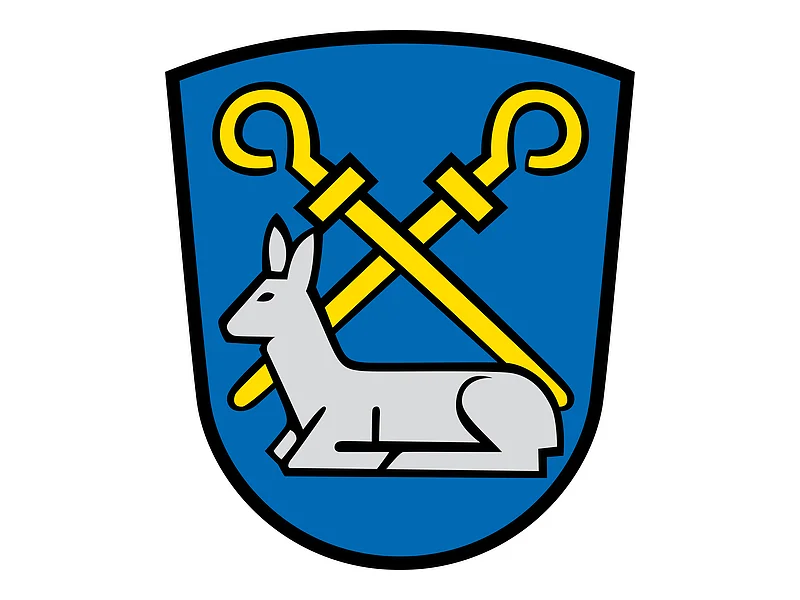 Wappen des Monheimer Ortsteils Rehau mit zwei gelben gekreuzten Abtstäben, unterhalb ein liegendes silbernes Reh auf einem blauen Hintergrund.