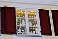 Adventskalenderfenster 09.12.2024 - Kolping Jugend Adventskalenderfenster mit Weihnachtsdekoration aus Papier in Form von Häusern, Tannenbäumen und Schneeflocken. Oben eine Lichterkette und in der Mitte des Fensters ein Schild mit der Zahl 9.