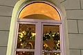Adventskalenderfenster 06.12.2024 - Schützen Adventskalenderfenster weihnachtlich dekoriert mit Weihnachtsbeleuchtung, einem Holzschlitten, Girlanden, Schneeflocken, einer Kerze, einer Figur eines Schützen und einer Siegesscheibe eines Schützenvereins.