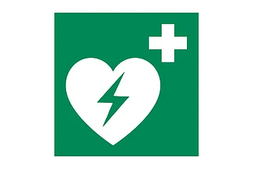 Symbol eines Defibrillators: ein Weißes Herz mit Blitz und weißes Kreuz auf einem grünem Hintergrund.
