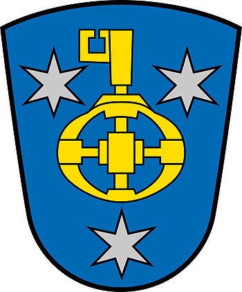Das Wappen von Wittesheim Wappen vom Monheimer Ortsteil Wittesheim, mit blauem Hintergrund, darauf drei silberne Sterne und ein gelbes Zahnrad mit Schlüssel in der Mitte.