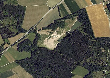 Luftaufnahme der Deponie Monheim:  Landschaft mit Feldern, Wäldern und einem unbebauten Gebiet in der Mitte.