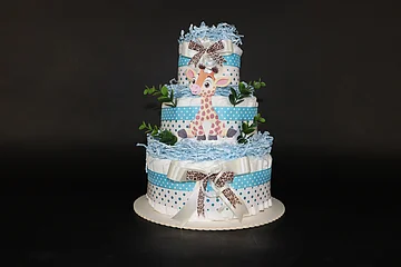 Dreistöckige Windeltorte mit blauen Bändern, Giraffendekor und grünen Blättern auf schwarzem Hintergrund.
