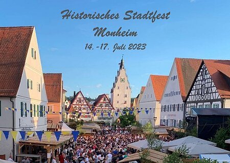 Foto des Fotobuchs der Stadt Monheim vom historischen Stadtfest in Monheim, auf der Titelseite des Fotobuch ist eine Menschenmenge zu sehen umgeben von Fachwerkhäusern Ständen und Dekorationen.