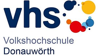 Logo der Volkshochschule Donauwörth mit den kleingeschriebenen dunkelblauen Buchstaben vhs und farbigen Kreisen rechts davon. Darunter der Schriftzug Volkshochschule Donauwörth in dunkelblauer Farbe. Alles auf weißem Hintergrund.