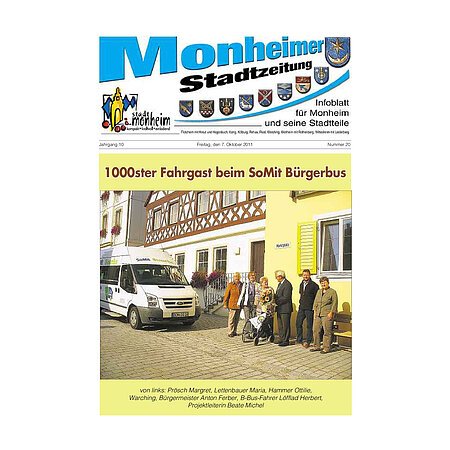 Titelblatt der Monheimer Stadtzeitung vom 07. Oktober 2011 mit der dazugehörigen Überschrift in blau/schwarz, Wappen der Stadt Monheim und der dazugehörigen Stadtteile und mit dem Logo der Stadt Monheim. Auf der Titelseite sind
sechs Personen, die neben einem weißen Bürgerbus und Fachwerkhäusern in Monheim stehen, ein gelber Rahmen außenrum. In dem Rahmen oben der Text: "1000ster Fahrgast beim SoMit Bürgerbus", unten Namensangaben zu den abgebildeten Personen.