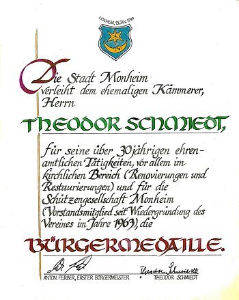 Urkunde der Stadt Monheim vom 15. Januar 1999 für Theodor Schmiedt mit Verleihung der Bürgermedaille, mit Unterschriften und dem Wappen der Stadt Monheim.