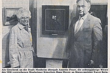 Schwarzweißfoto aus Donauwörther Zeitung  einer älteren Frau und eines Mannes neben einem gerahmten Bild in einer Ausstellung.