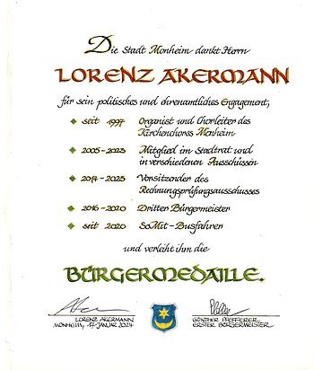 Urkunde der Stadt Monheim für Lorenz Akermann mit mit Aufzählung der Tätigkeiten und Verleihung der Bürgermedaille, darunter zwei Unterschriften und ein Wappen der Stadt Monheim. Datiert 17. Januar 2024.