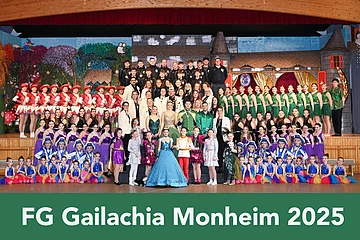 Gruppenfoto von FG Gailachia Monheim 2025 mit vielen Personen in bunten Kostümen auf einer Bühne vor einem Bühnenbild.