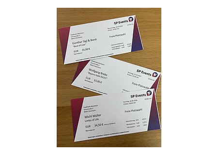 Kartenvorvekauf in der Tourist-Information Monheim. Muster für Konzertkarten von SP Events in der Stadthalle Monheim mit Künstlernamen, Datum und Preisen auf Holztisch. Günter Sigl, Michl Müller und Wolfgang Krebs .