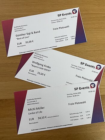 Kartenvorvekauf in der Tourist-Information Monheim. Muster für Konzertkarten von SP Events in der Stadthalle Monheim mit Künstlernamen, Datum und Preisen auf Holztisch. Günter Sigl, Michl Müller und Wolfgang Krebs .