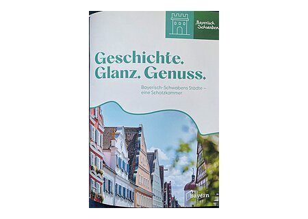 Titelblatt mit dem Text „Geschichte. Glanz. Genuss. Bayerisch-Schwabens Städte – eine Schatzkammer“ und Bild von historischen Häusern. Neue Broschüre vom Tourismusverband Allgäu-Bayerisch-Schwaben.
