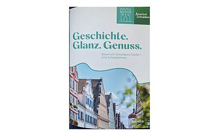 Titelblatt mit dem Text „Geschichte. Glanz. Genuss. Bayerisch-Schwabens Städte – eine Schatzkammer“ und Bild von historischen Häusern. Neue Broschüre vom Tourismusverband Allgäu-Bayerisch-Schwaben.