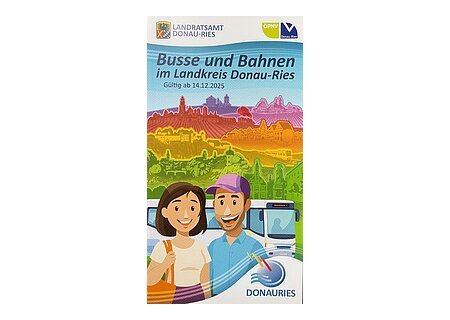 Titelblatt des neuen Fahrplans für "Busse und Bahnen im Landkreis Donau-Ries", die alle aktuellen Bus- und Bahnfahrpläne im Landreis Donau-Ries beinhalten. Gültig ab 14.12.2025 Auf dem Titelblatt ist eine Zeichnung von zwei Personen vor Bus und farbigen Landschaften.