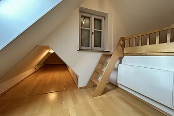 Dachzimmer mit Holzhochbett, kleiner Dachluke und Fenster mit Rollladen, heller Holzboden