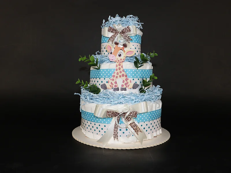 Windelrella Windeltorten - Windeltorte Kleine Giraffe Dreistöckige Windeltorte mit blauen Bändern, Giraffendekor und grünen Blättern auf schwarzem Hintergrund.