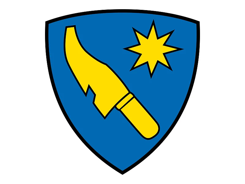 Das Wappen des Monheimer Stadtteils Flotzheim. Auf dem Wappen ist ein gelbes Schwert und ein gelber Stern auf blauem Hintergrund zu sehen.