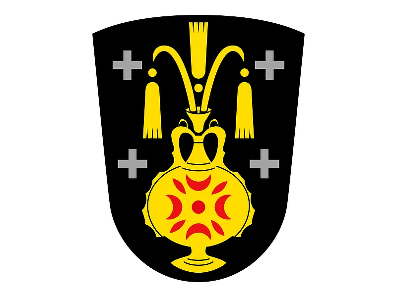 Das Wappen des Monheimer Stadtteils Kölburg: gelber Krug auf schwarzem Hintergrund, auf dem Krug rote Muster. Links und rechts jeweils zwei graue Kreuze.