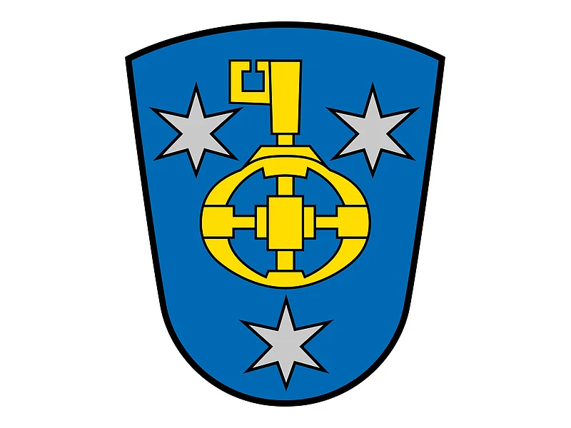 Wappen vom Monheimer Ortsteil Wittesheim, mit blauem Hintergrund, darauf drei silberne Sterne und ein gelbes Zahnrad mit Schlüssel in der Mitte.