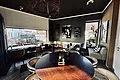 Pizzeria Va Bene - Gemühtlicher Innenraum der Pizzeria Innenraum eines Cafés mit runden und eckigen Tischen, Stühlen und großem Fenster mit Blick nach draußen
