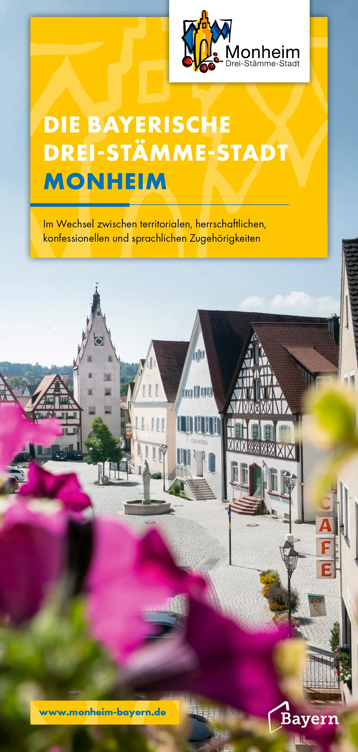 Folder Drei-Stämme-Stadt Titelseite des Folders "Die Bayerische Drei-Stämme-Stadt Monheim" mit dem Logo der Stadt Monheim oben rechts im Eck. Auf dem Foto die Ansicht der historischen Altstadt Monheim, mit unscharfen rosa Blumen im Vordergrund.