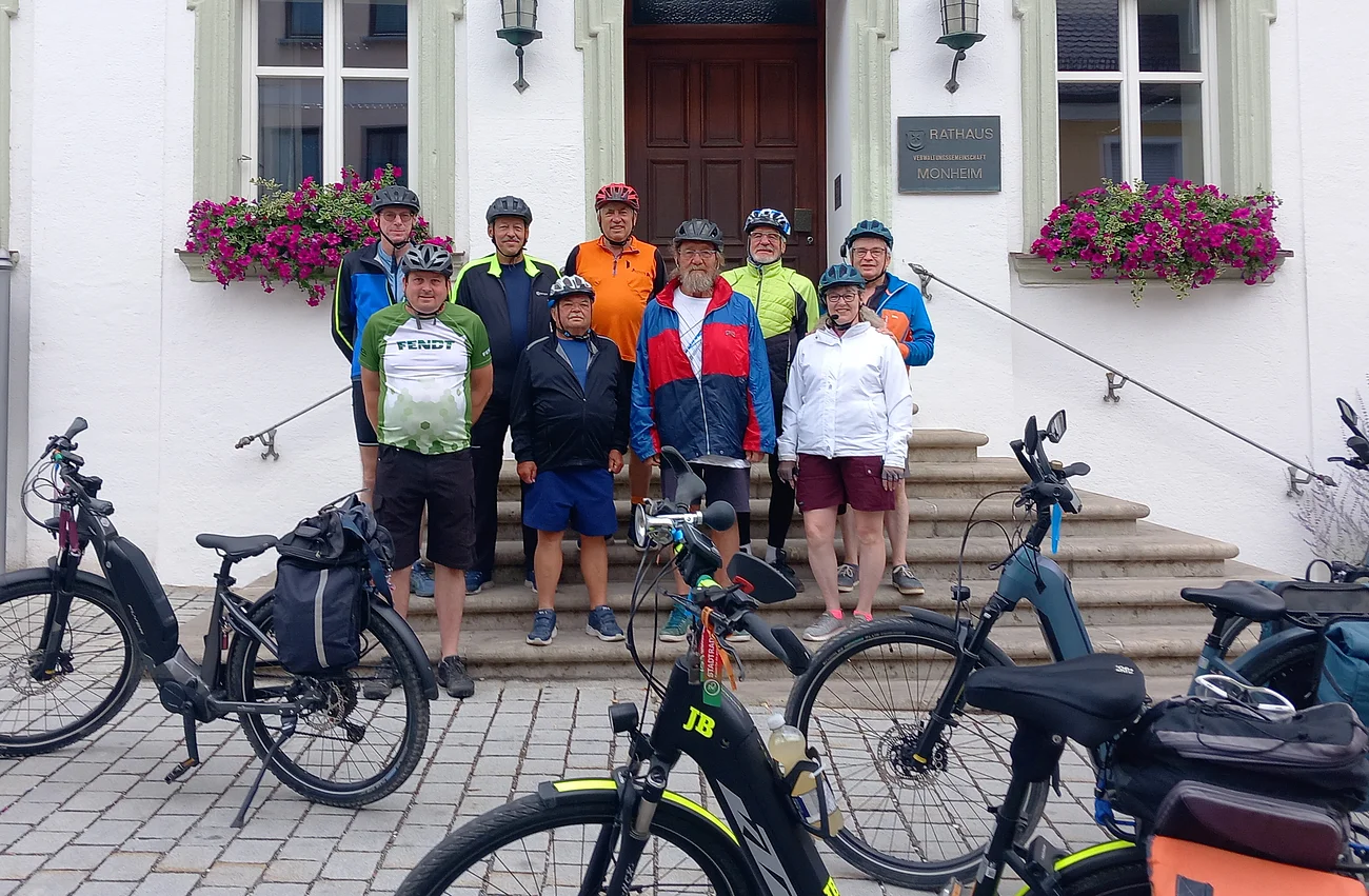 Neun Radfahrer mit Helmen stehen vor dem Rathaus Monheim, davor sind mehrere E-Bikes abgestellt. Auftakt zum Stadtradeln 2026 in Monheim