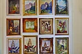 Das Lieblingsmotiv von Kunstmaler Hans Mayer Zwölf gerahmte Gemälde mit Landschaften, Gebäuden, Blumen und Figuren an weißer Wand angeordnet.